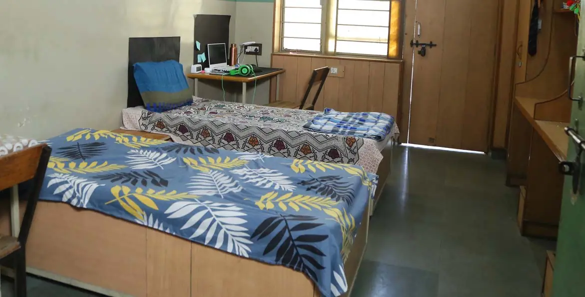 Hostel room with bed, study table and window