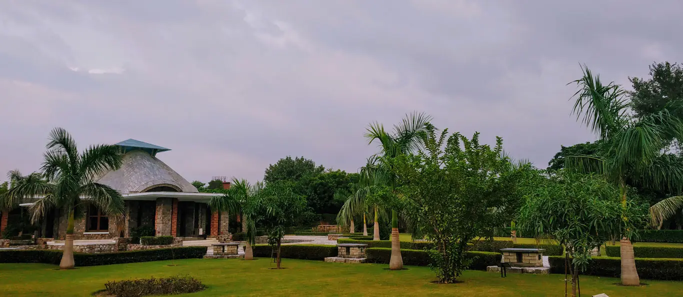 Landscaped campus grounds with palm trees and the faith centre