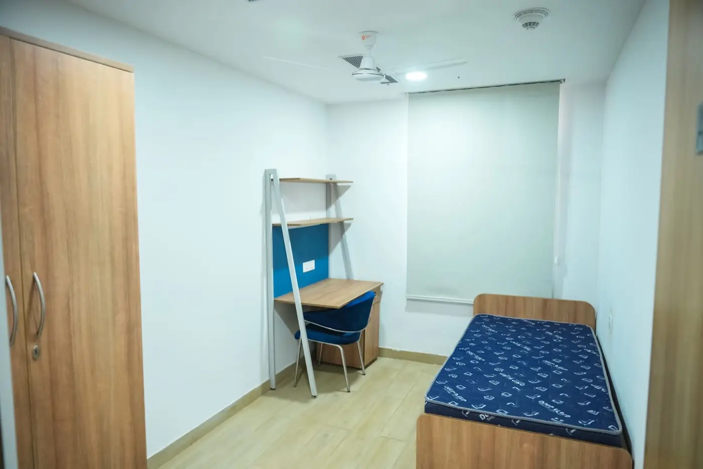 Hostel room with bed, wardrobe and study desk