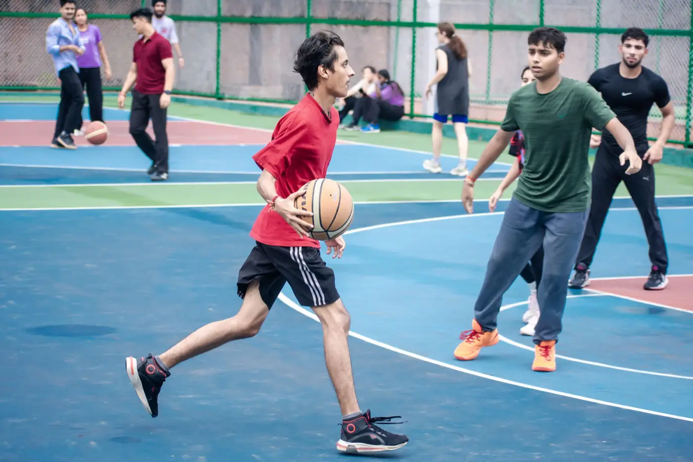 Outdoor basketball court with students playing
