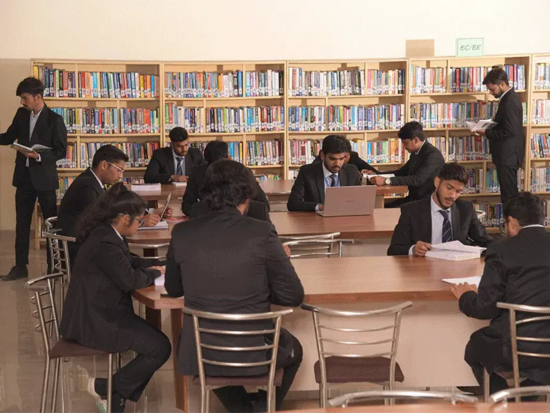 Students studying at library reading tables