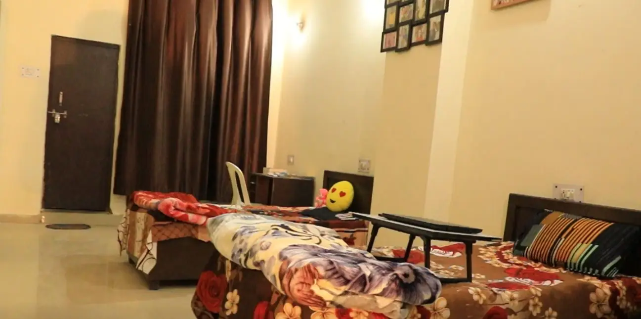 Hostel room with beds and study desk