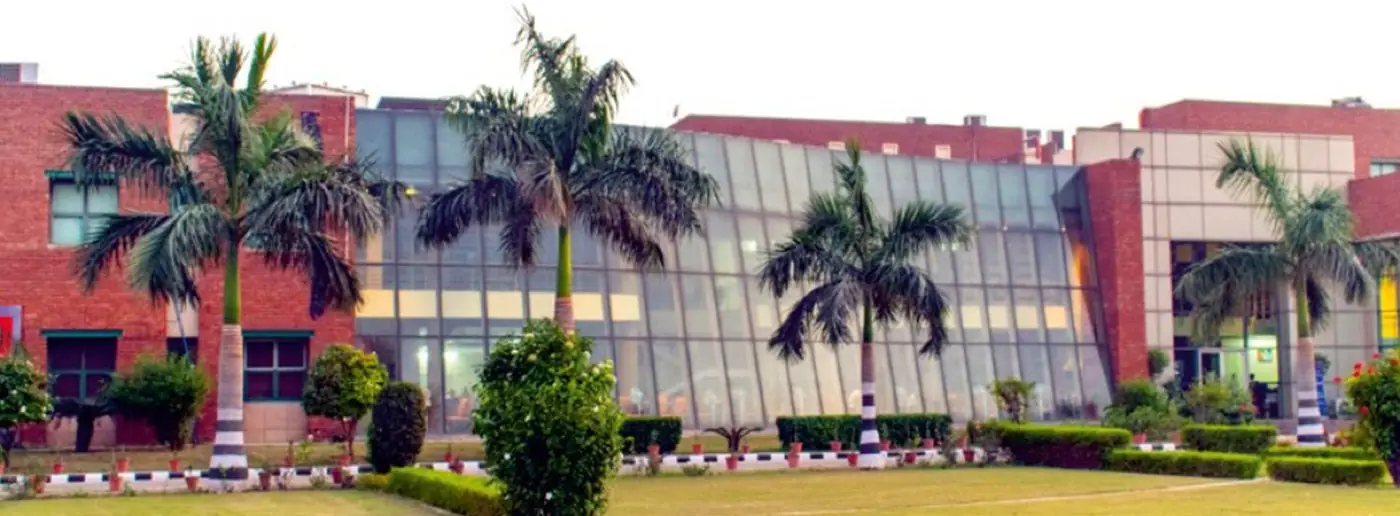 Glass-fronted academic block with palm-lined lawn