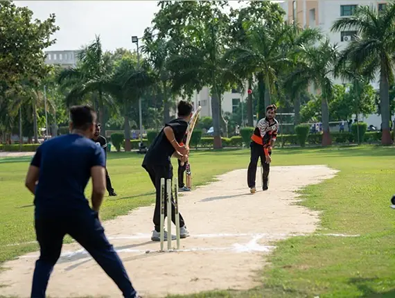 Students playing cricket on the campus ground