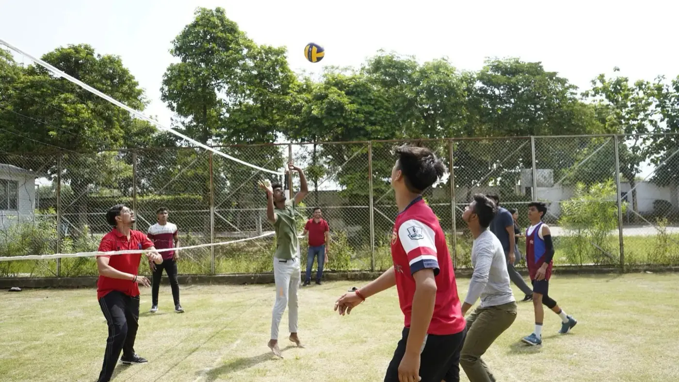 Students playing volleyball on the outdoor court