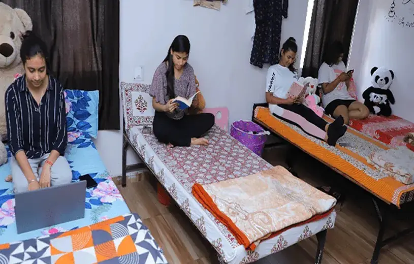 Hostel room with students studying on their beds